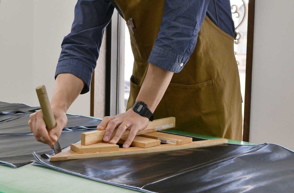 傘づくりが描く航跡-裁断台に広がる無数の裁ち跡-